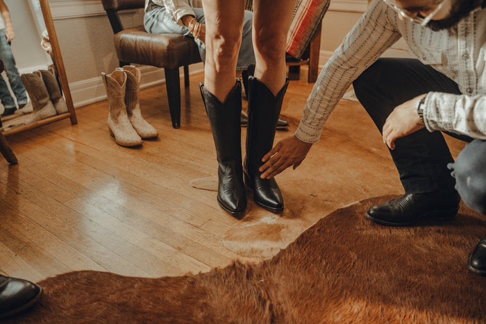 Checking the fit of a pair of black cowboy boots at Chisos HQ