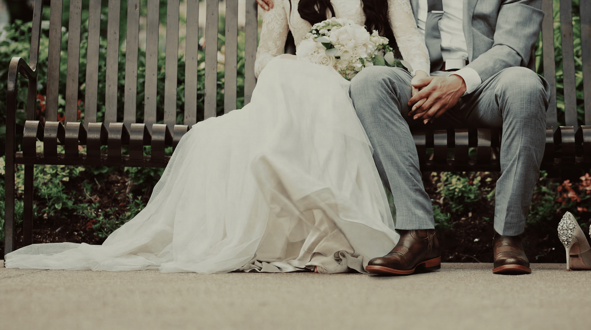 Groom wearing Chios No. 7 wedding cowboy boots seated next to bride outdoors