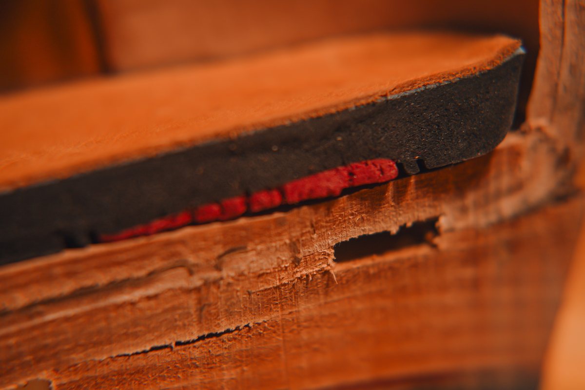 Macro of the cut heel: the comfort insole’s leather top and cushioning, with the red gel pad underneath