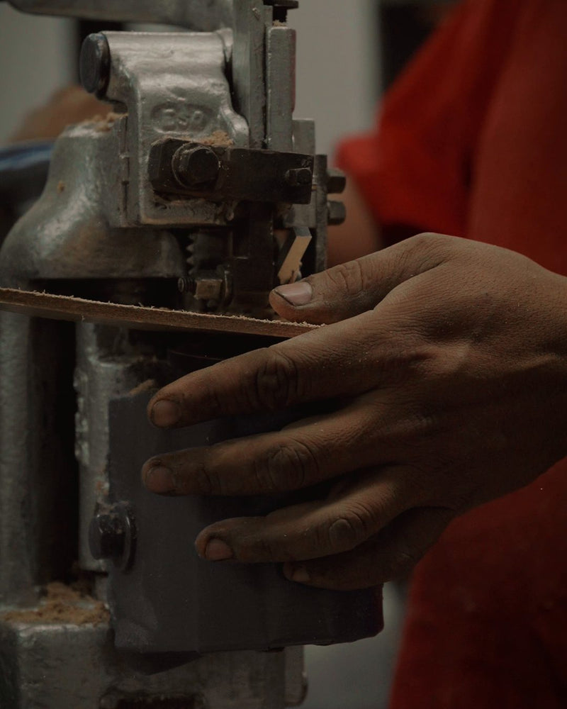 A bootmaker feeding a leather insole through the channel-cutting machine